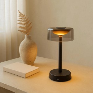 Brilliant LED Tischleuchte Razor schwarz mit Rauchglas-Schirm auf Tisch. Kabellose, dimmbare Tischlampe für warmes Licht.