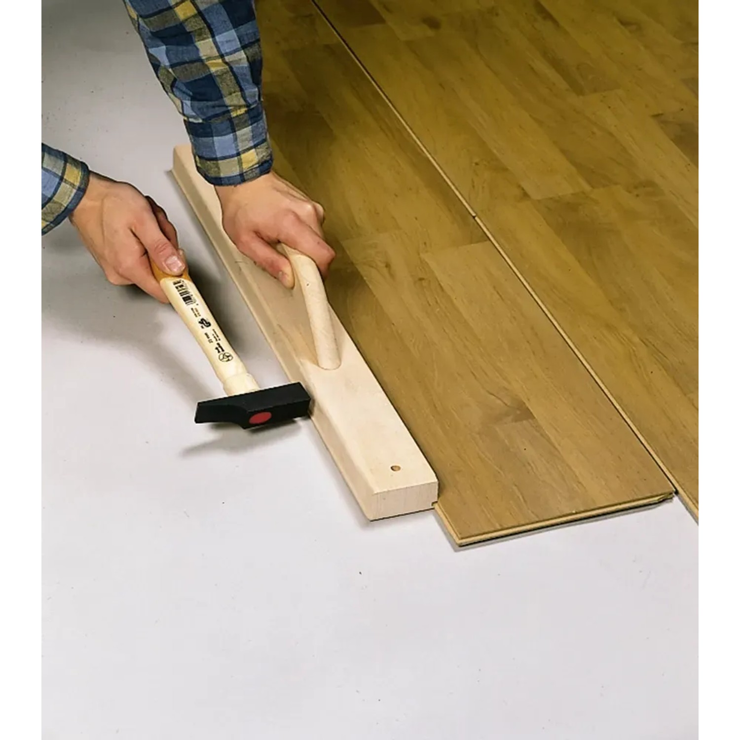LUX Schlagleiste Comfort beim Verlegen von Laminat mit Hammer. Maurer-, Fliesenleger- & Verlegewerkzeug.