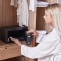 Schwarzer Yale Tresor High Security Safe 9,6 l im Schrank mit Frau, die eine Uhr hineinlegt.