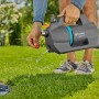 Gardena Gartenpumpe 4200 Silent Set in Aktion: Graue Pumpe mit blauem Akzent pumpt Wasser in den Garten.