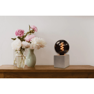 Dekorative LED Filament Lampe E27, 4W, 1800K, dimmbar, Rauchglas, auf einem grauen Sockel.