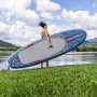 Frau trägt blaues Bestway SUP Allround Board Oceana (305 cm) am See.