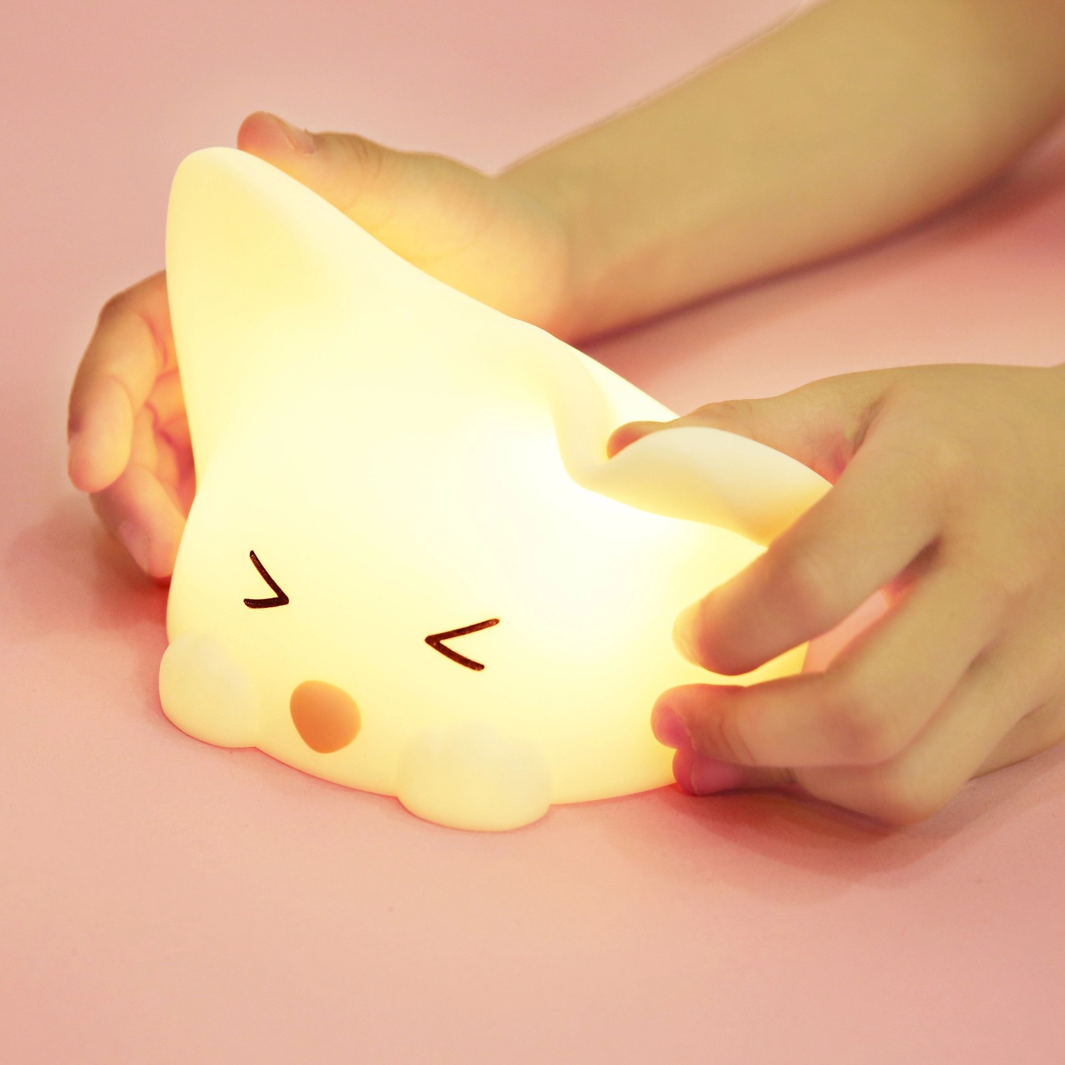 Dimmbares LED Kinder-Nachtlicht Catty Cat mit Soundeffekt, in Kinderhand.