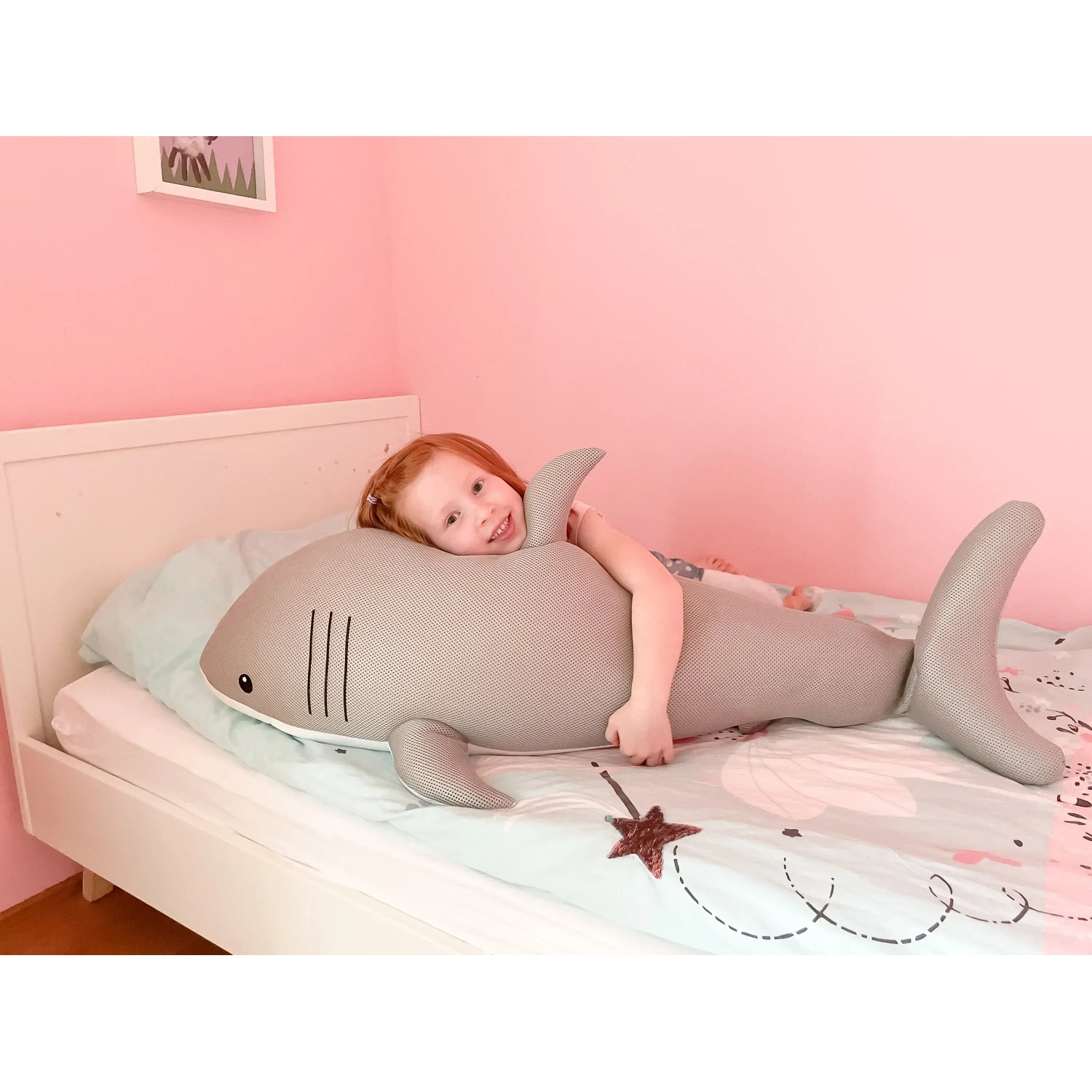 Mädchen liegt auf grau-weißem Westmann Pool Buddy Hai als Sitzsack/Schwimmtier im Kinderzimmer.
