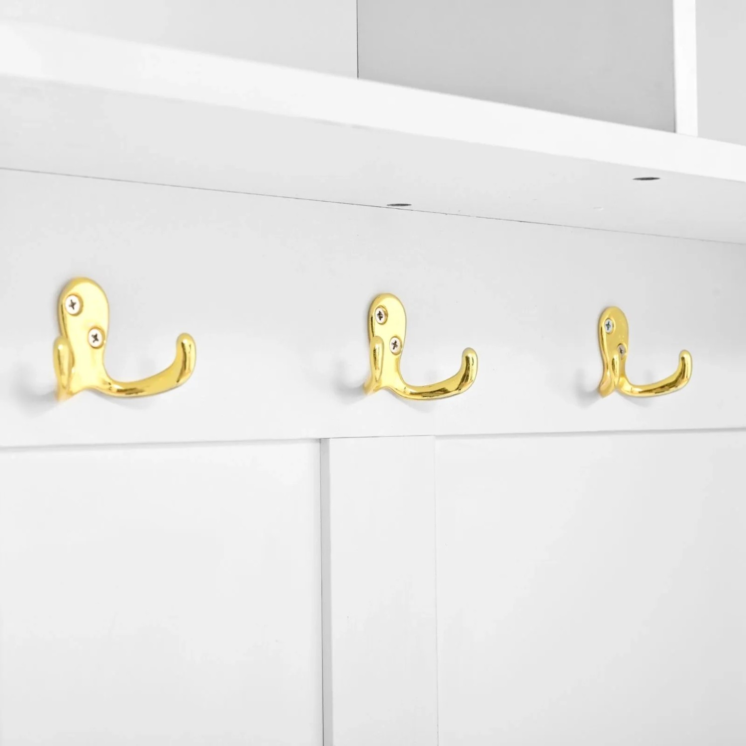 Drei goldene Garderobenhaken auf weißer Platte mit integrierter LED-Beleuchtung. Für Flurgarderobe.