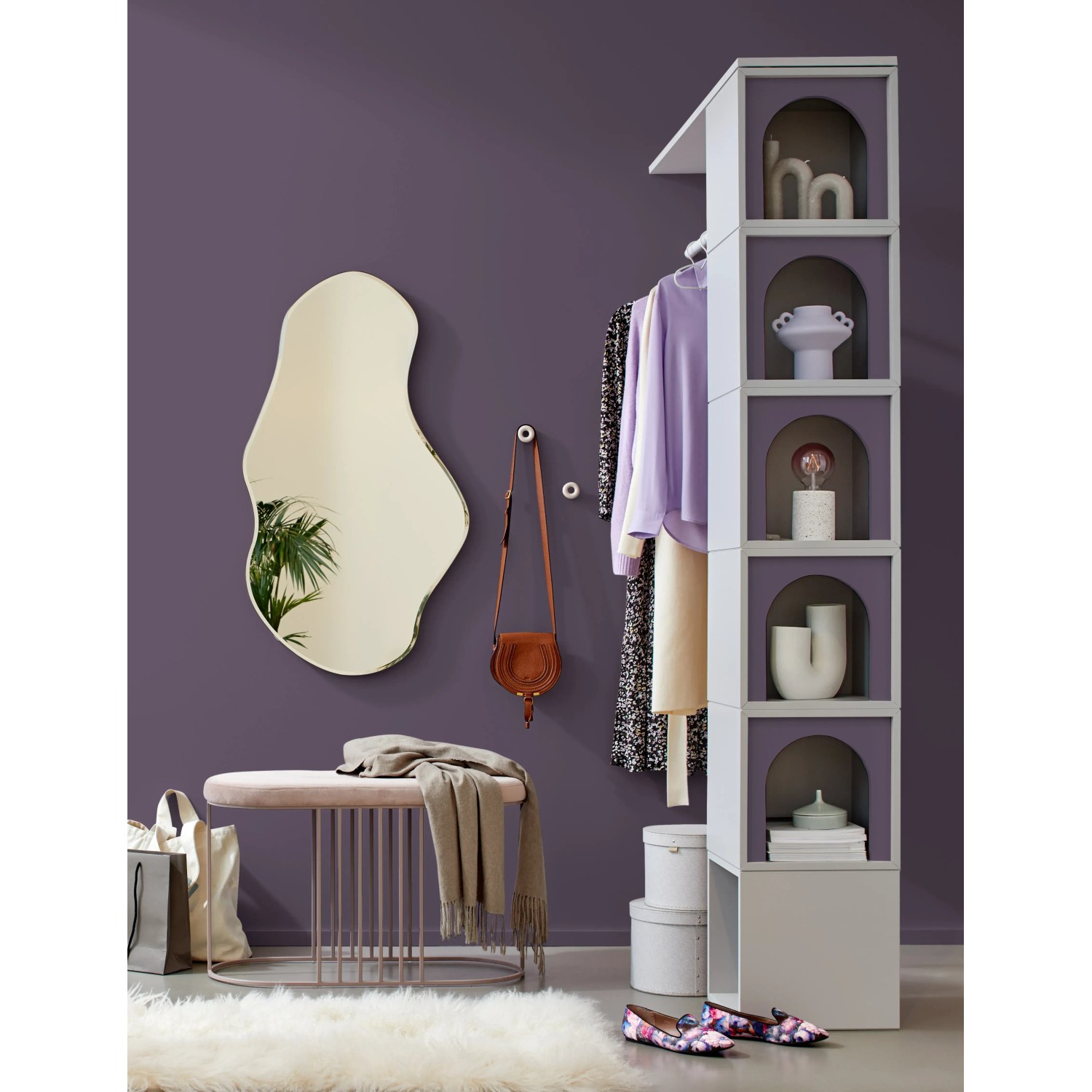 Raum in Feigenviolett mit Alpina Wandfarbe, Spiegel, Bank und Regal.