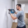 Mann bohrt mit Bosch Akku-Bohrhammer GBH 18V-18 ein Loch in die Wand.