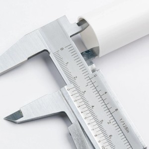 Weiße Orion Lightstyle Kerzenhülse E14 mit Messschieber, Detailaufnahme.