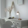 Paul Neuhaus LED-Tischleuchte Pino in Altmessing auf weißem Tisch. Schreibtischlampe mit Touchdimmer.