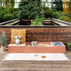 MUDDY BUDDY Sandkasten Space Saver in Puderrosa mit Spielzeug und Wasserwanne.