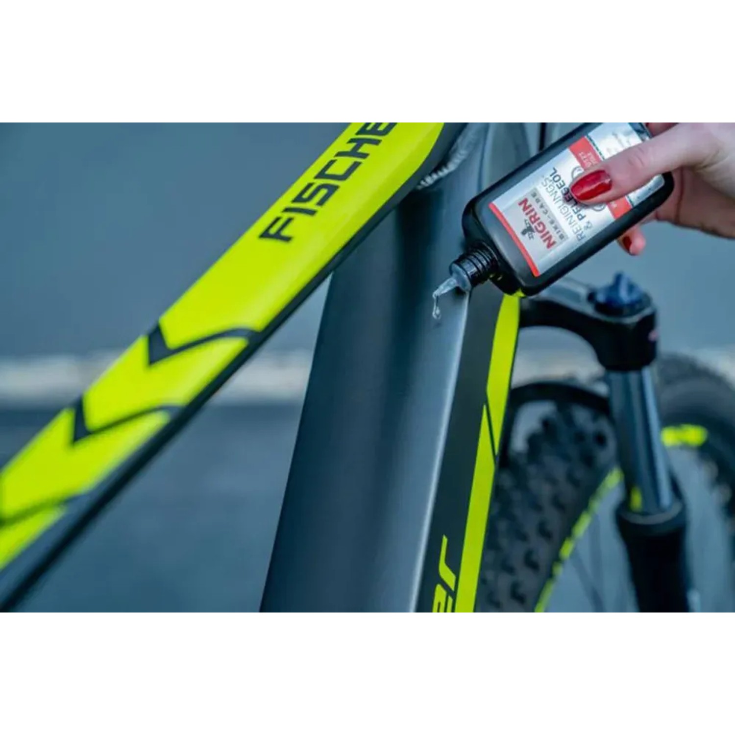 Nigrin Bike-Care Reinigungs- und Pflegeöl (100ml) in Anwendung auf einem Fahrrad.