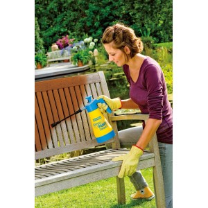 Frau sprüht Holzbank mit Gloria Drucksprüher Spray&Paint Compact. Drucksprühgerät in Gelb/Blau.