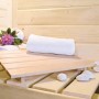 Innenansicht Karibu Sauna Natur mit Handtuch, Deko und Liegefläche aus Holz.