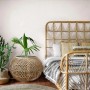 Bricoflor Leinen Tapete in Creme Weiß an Schlafzimmerwand mit Rattanbett und -tisch.