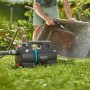 Gardena Akku-Gartenpumpe 3000 Silent 18V beim Bewässern einer Schubkarre im Garten.