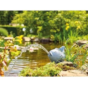 Oase Wasserspeier Fisch aus Polyresin im Gartenteich mit Wasserstrahl.