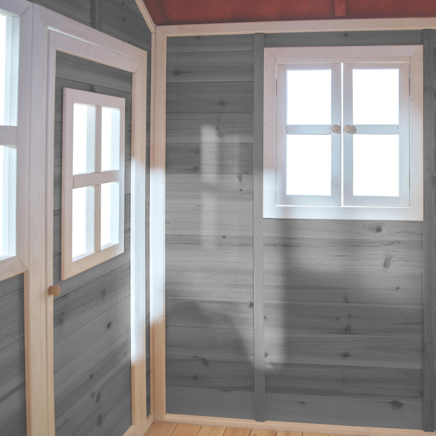 Innenansicht: Graues EXIT Loft 500 Holzspielhaus mit Fenster und Holzwänden.