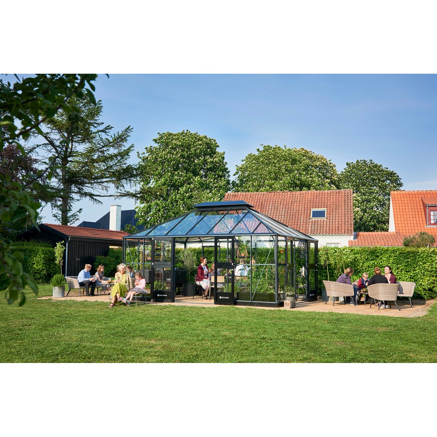 Juliana Gewächshaus Grand Oase 18, anthrazit-schwarz, mit Personen im Garten.