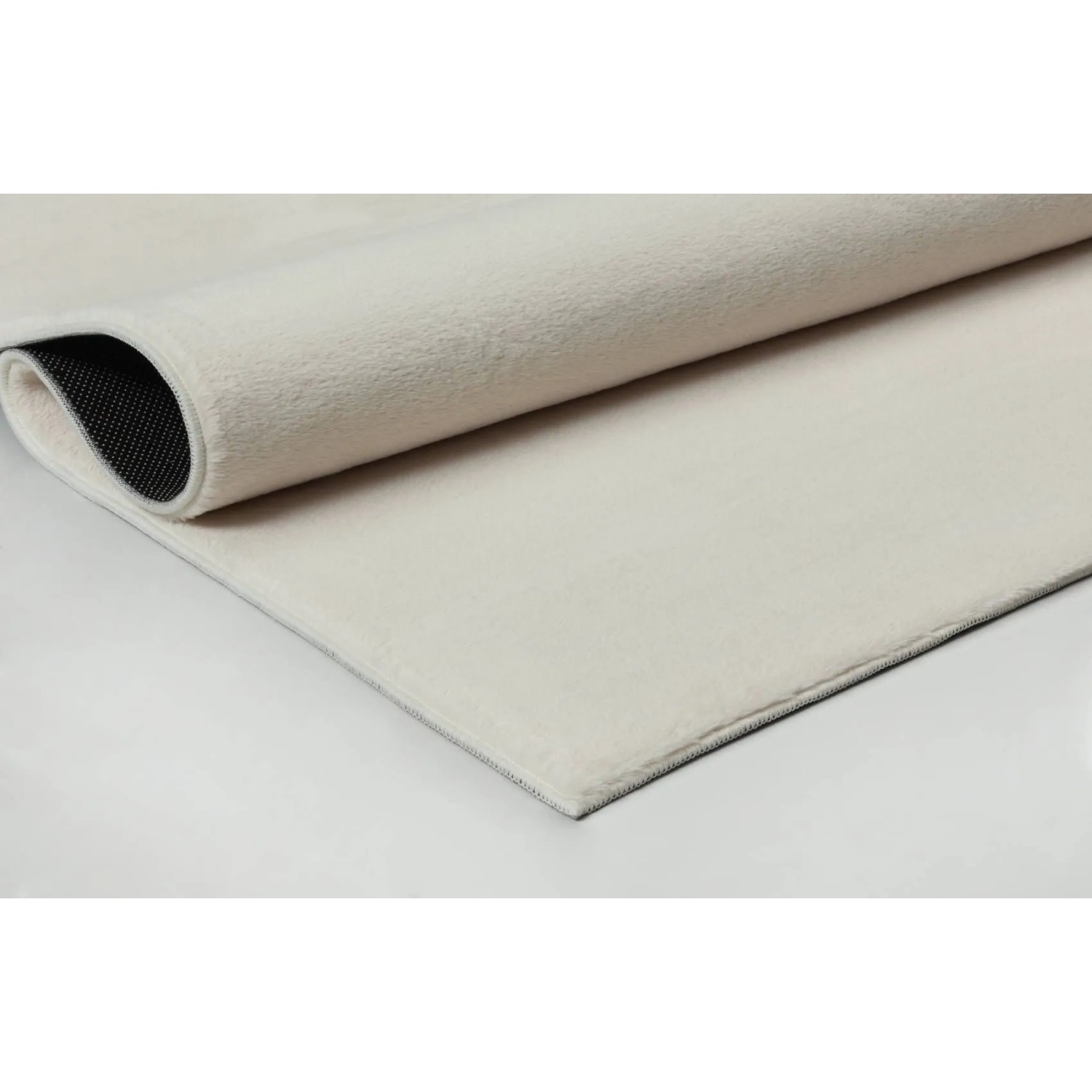 Beiger Floornovo Kurzflor Teppich (280x200 cm), gerollt, mit Filz-Rückseite.