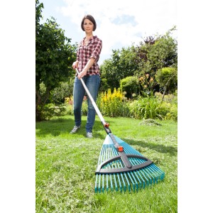 Frau rechen mit Gardena Verstellbesen Combisystem Laub und Grasschnitt zusammen.