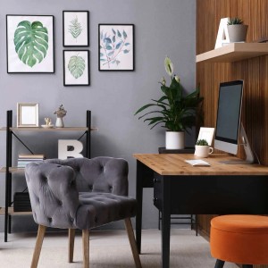 Wohnraum mit beiger Wandfarbe, grauem Sessel und Schreibtisch mit PC.