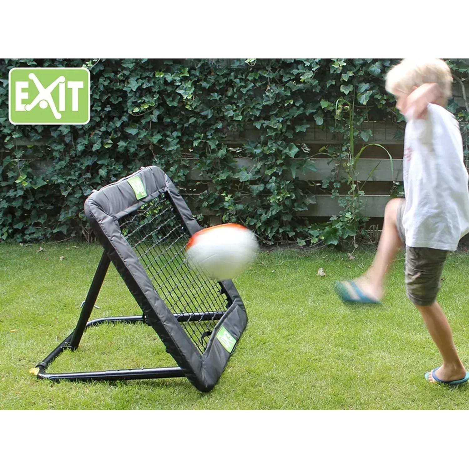 EXIT Kickback Rebounder M: Kind trainiert Balltechnik mit dem verstellbaren Multisport-Rebounder im Garten.