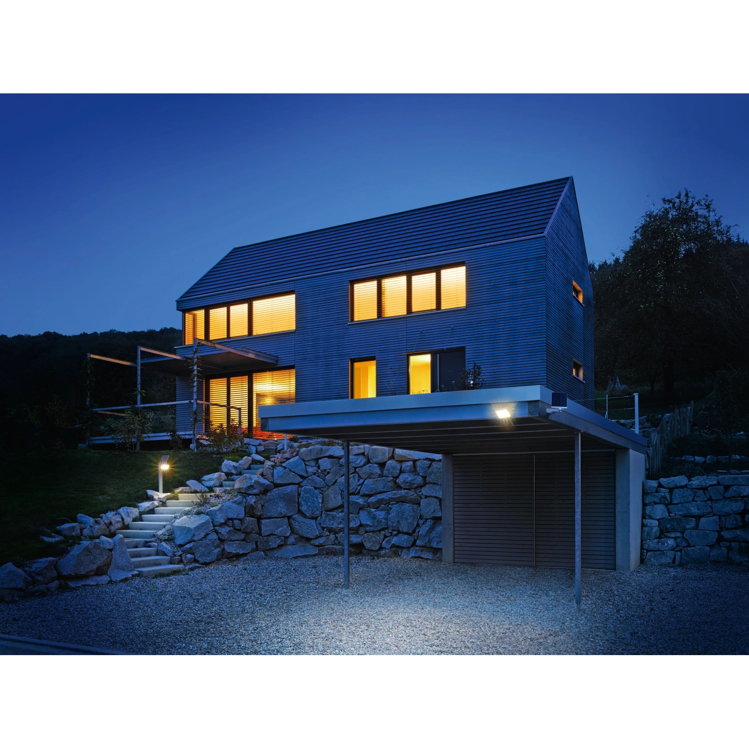 Beleuchtetes Haus mit Steinel LED Solar Außenwandleuchte X Solar L-S Silber am Carport.