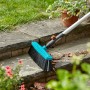 Gardena Straßenbesen Combisystem mit Holzstiel im Einsatz zum Kehren von Laub auf einer Steintreppe.