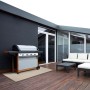 Wetterfester KARAT Outdoor Teppich Parma 180x300 cm unter Grill auf Terrasse.