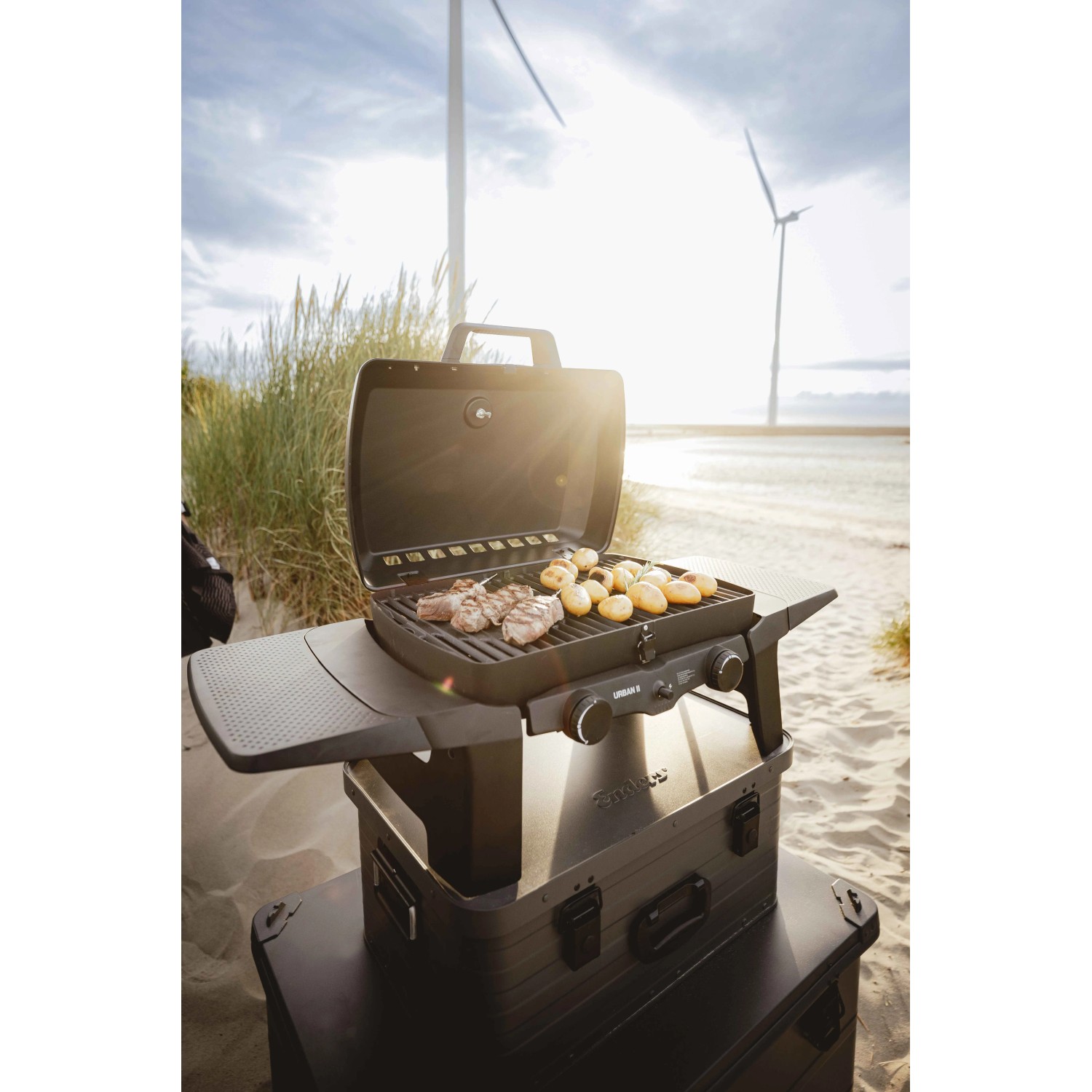 Enders Urban II Gasgrill: Mobiler Grill mit Speisen auf dem Rost, ideal für Balkon und unterwegs.