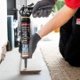 Person trägt Soudal Fix All X-Treme Power Montagekleber mit Kartuschenpistole auf Holzleiste auf. Hohe Haftung.