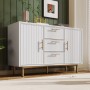 Weiße Merax Kommode mit 3 Schubladen, geriffelten Türen, goldenen Griffen und Metallfüßen für Wohnzimmer.