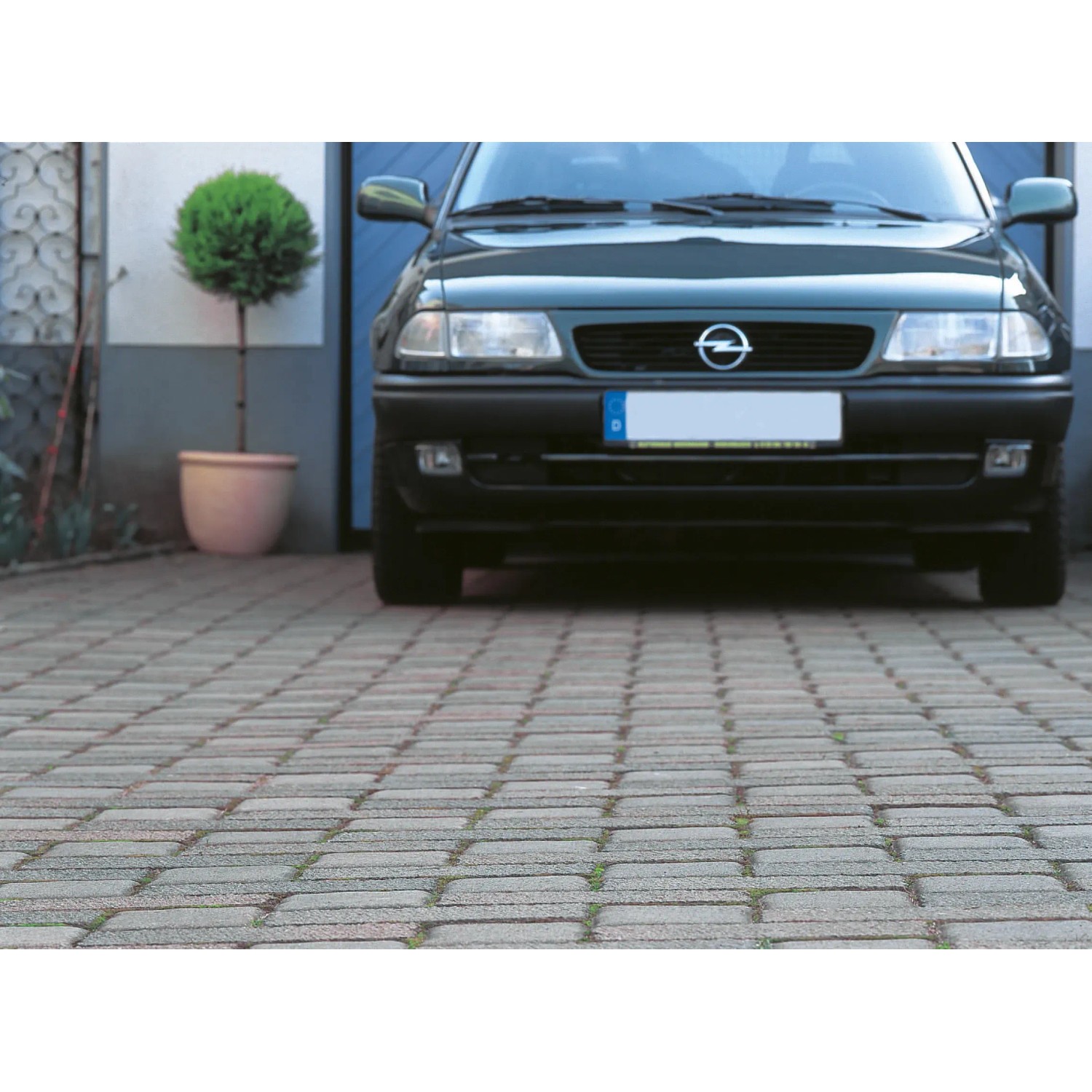 Anwendung von schwarzem Unterbodengewebe (5 m x 2 m) unter einer gepflasterten Garageneinfahrt.