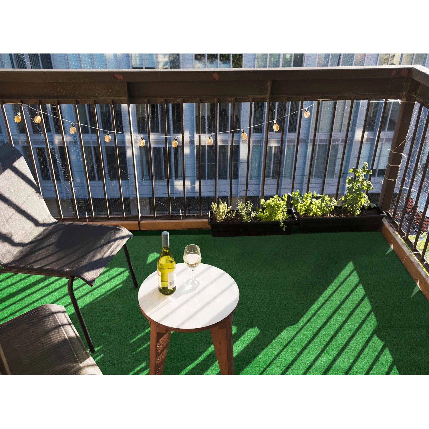 Grüner Primaflor Rasenteppich Park auf einem Balkon mit Tisch und Stühlen.