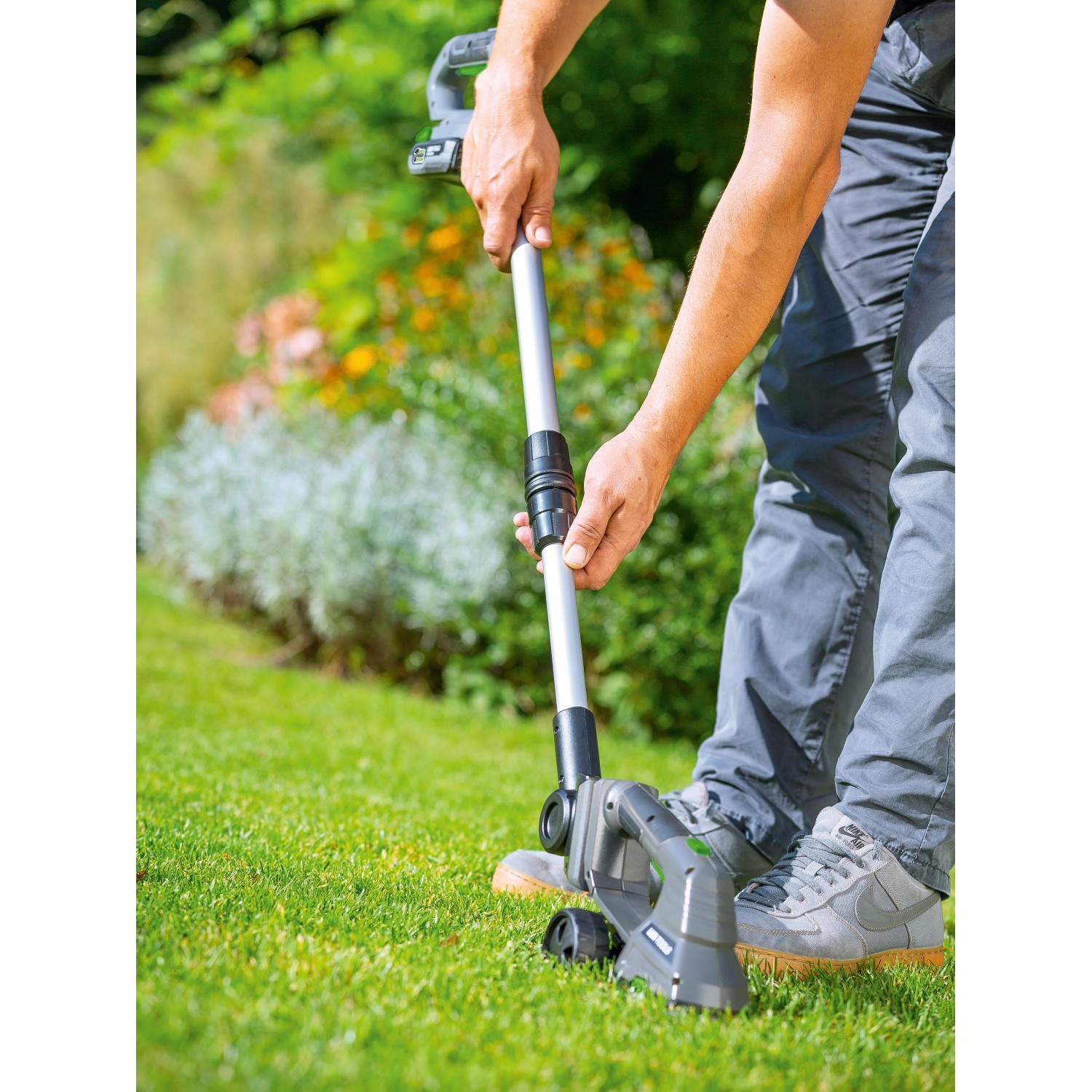 LUX Akku-Grasscheren-Set mit Stiel und Radsatz im Einsatz auf Rasen.
