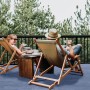 Szene mit blauem Primaflor Rasenteppich: Paar entspannt auf Balkon mit Kunstrasen.