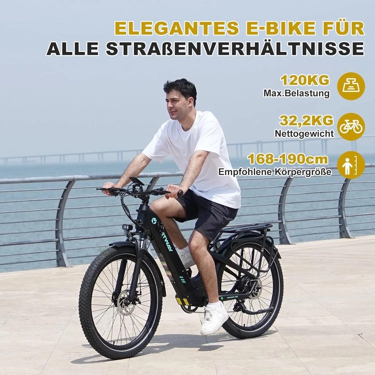Schwarzes HITWAY E-Bike BK16 mit 26 Zoll Geländereifen, 18Ah Akku und 7-Gang, gefahren von einem Mann am Wasser.