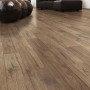 Kaindl Comfort Laminat 7 mm Hickory mit authentischer Holzmaserung im Wohnzimmer. Dunkelbrauner Bodenbelag.