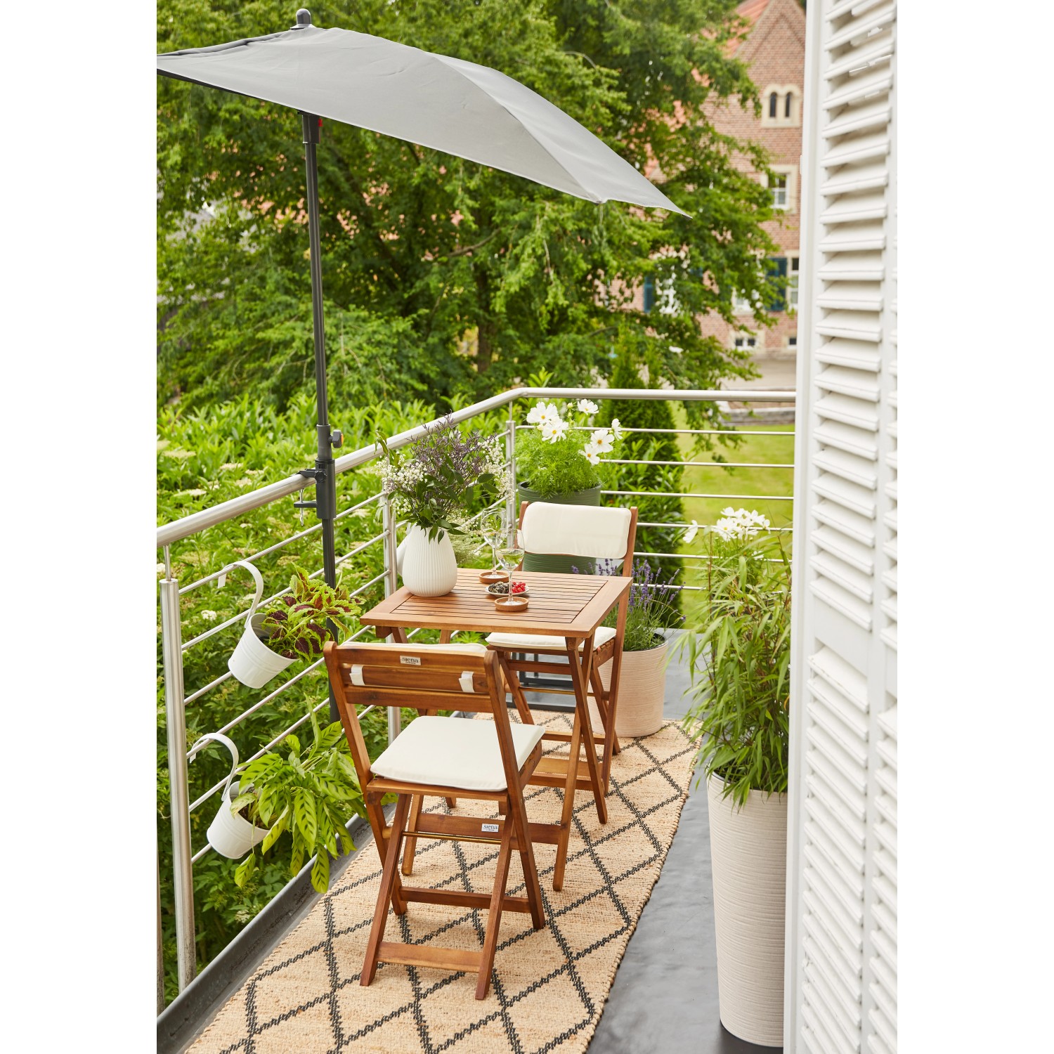 Siena Garden Balkonschirmklammer Avio, anthrazit, am Balkongeländer mit Schirm befestigt.