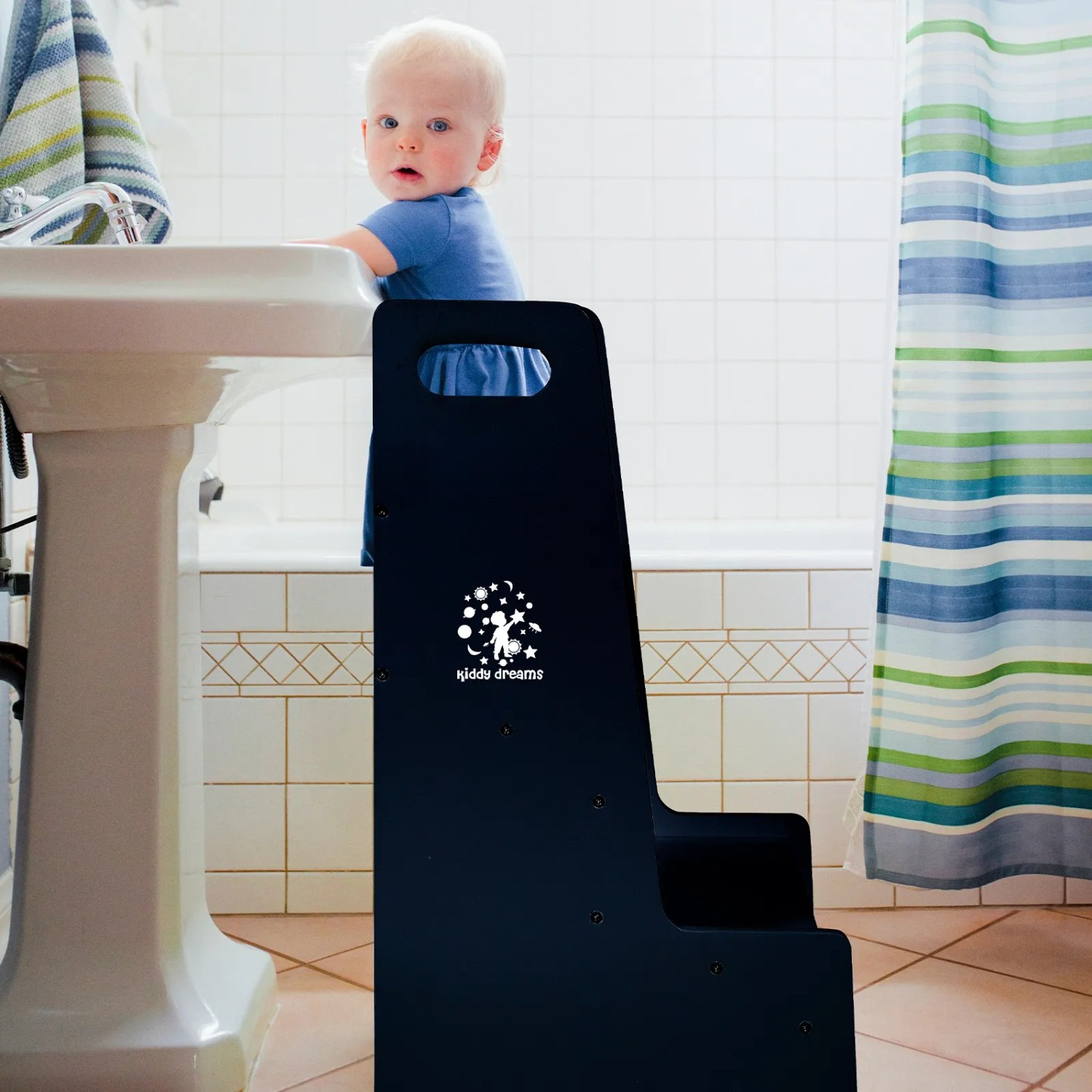 Schwarzer CCLIFE Kiddy Dreams Tritthocker aus Holz mit Kind im Badezimmer.