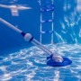 Weißer Gre Automatik-Poolreiniger im Pool unter Wasser mit Poolleiter im Hintergrund.