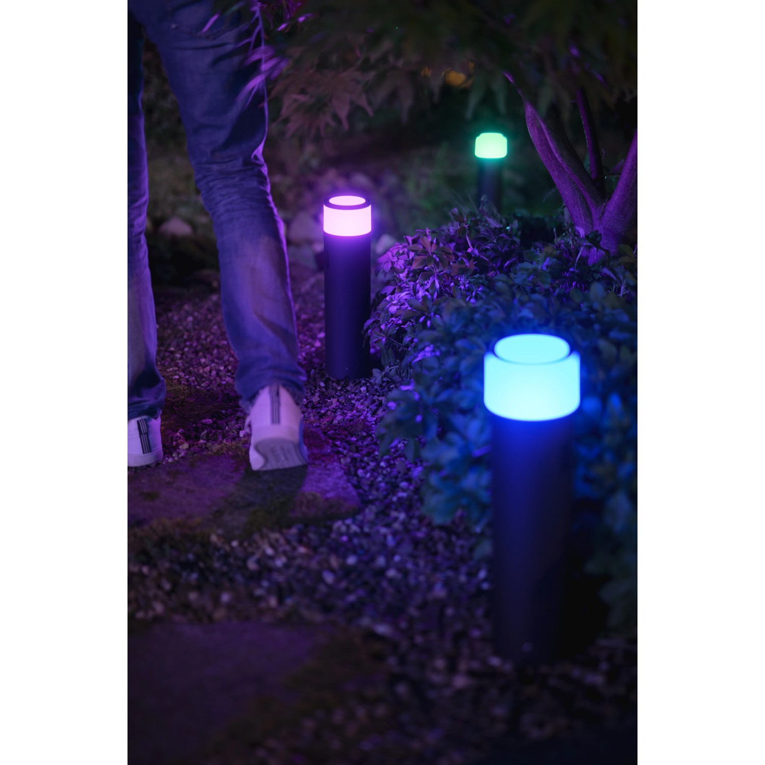 Philips Hue Calla Sockelleuchte im Garten mit farbigem Licht. Erweiterung für smarte Außenbeleuchtung.