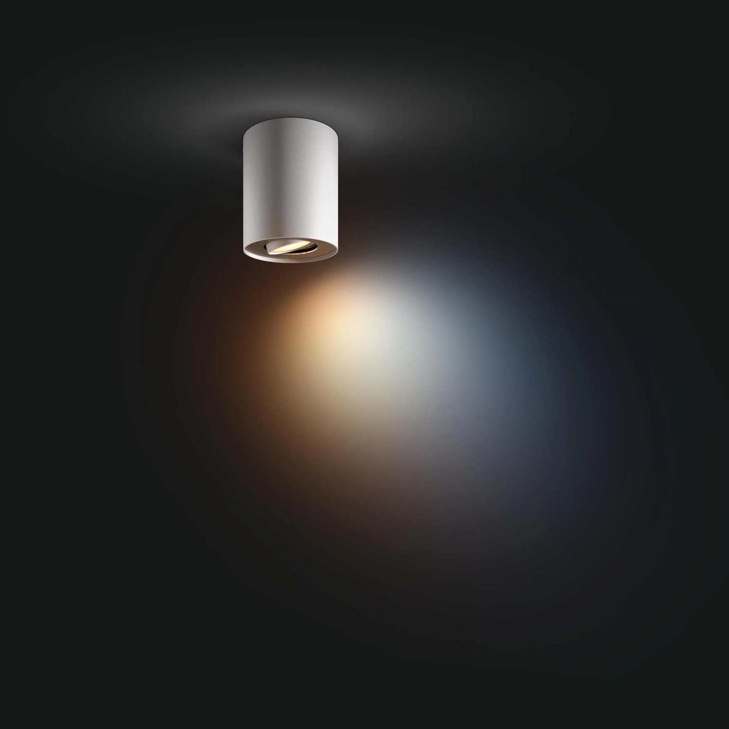 Weißer Philips Hue LED-Aufbauspot Pillar White Ambiance an dunkler Decke.