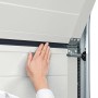 Detailaufnahme: Hand prüft Dichtung eines reinweißen IsoMatic Garagentors.