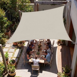 Rechteckiges taupe Sonnensegel über Esstisch im Garten, spendet Schatten für Balkon & Terrasse. UV Schutz.