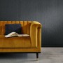 Schwarze Erismann Vliestapete Uni von Guido Maria Kretschmer an Wand hinter Sofa.