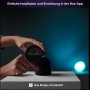 Schwarze Philips Hue Secure Kamera mit Standfuß in der Hand, geeignet für die Überwachung.