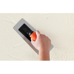 Hand mit Alpina Effekt Kelle für Putz- und Strukturfarben an Wand.