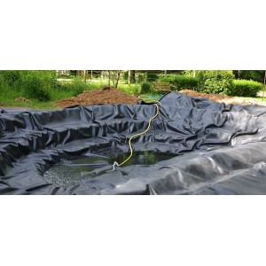 Schwarze Aquagart Teichfolie (7x6m) aus PVC im Gartenteich mit Wasser und gelbem Schlauch.