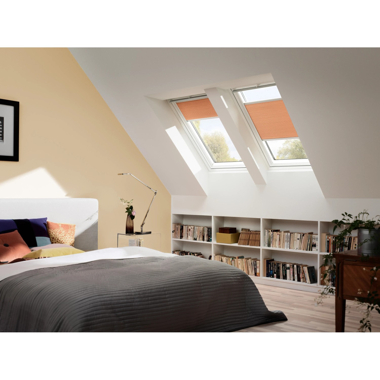 Helles Schlafzimmer mit zwei weißen Velux Dachfenstern GGL MK06 2070 mit orangefarbenen Rollos.